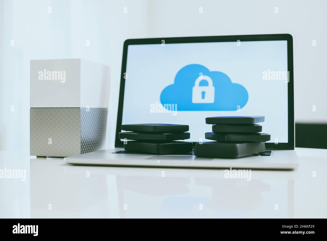 Laptop on the desk with network attached storage. Computer, nas and stack of hard drives on the table. Cloud technology, online disk, remote backup, s Stock Photo