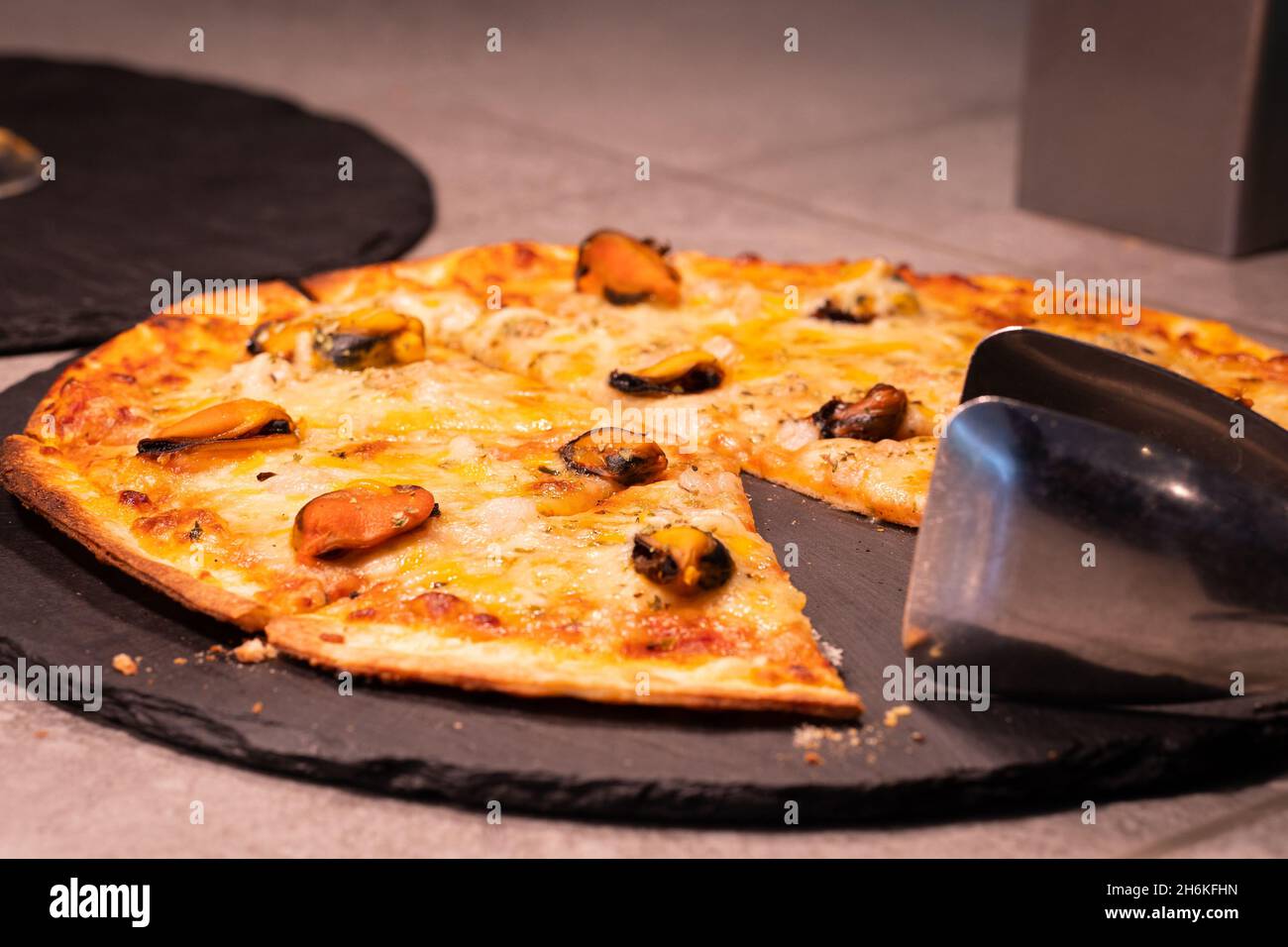 Delicious seafood pizza with mussels, ready to eat. Stock Photo