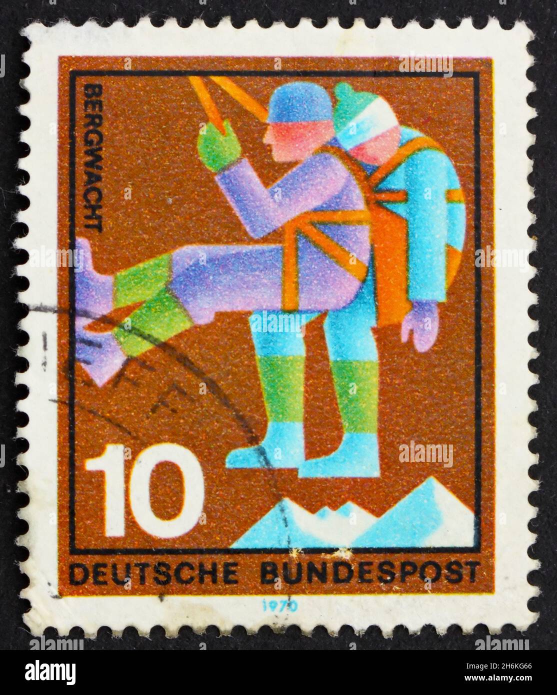 GERMANY - CIRCA 1970: a stamp printed in the Germany shows Mountain Climber, rescuer bringing down casualty, honoring various voluntary services, circ Stock Photo
