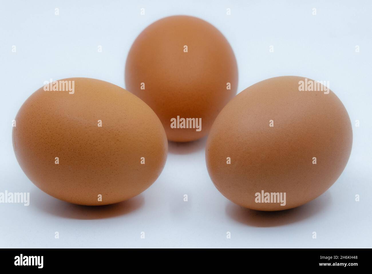Three brown eggs isolated on a white background, representing healthy food, nutrition and natural protein. Stock Photo