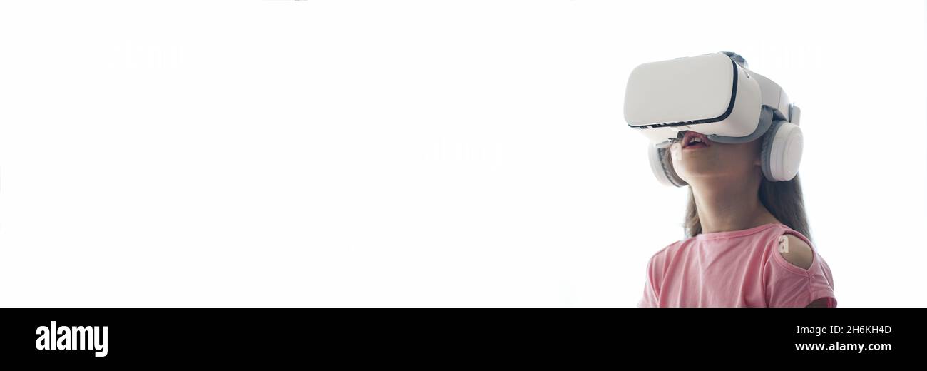 A banner, a girl having fun in virtual reality glasses, stands on a white background. Copy space. High quality photo Stock Photo