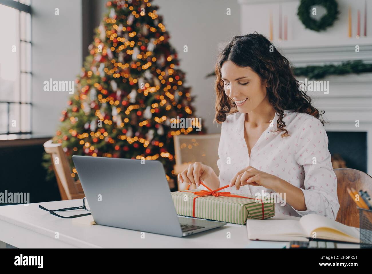 Beautiful Italian woman business lady decorating Xmas present at workplace during Christms holidays Stock Photo