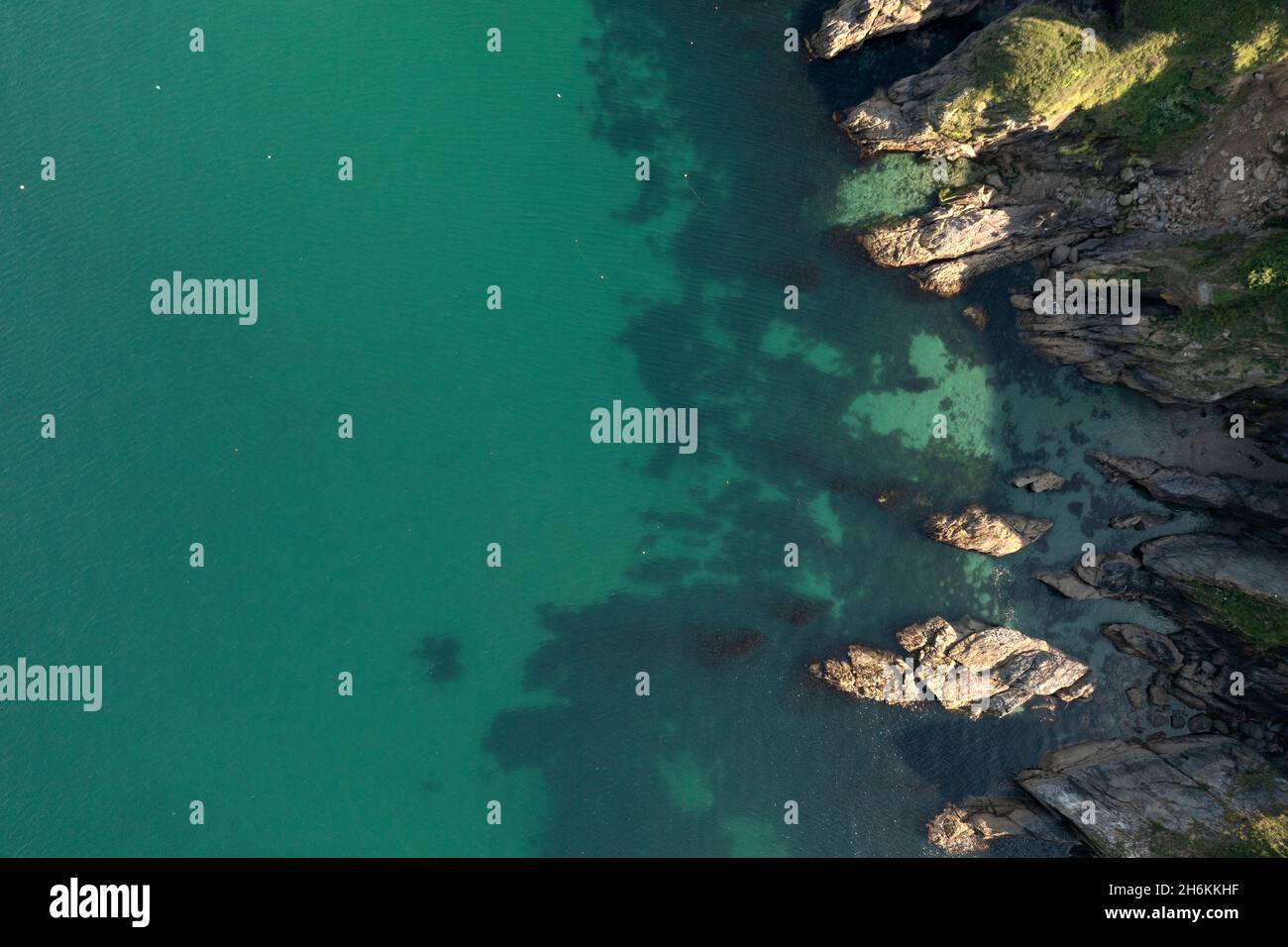 Aerial image of the rocky shoreline and clear water off the Cornish coast Stock Photo