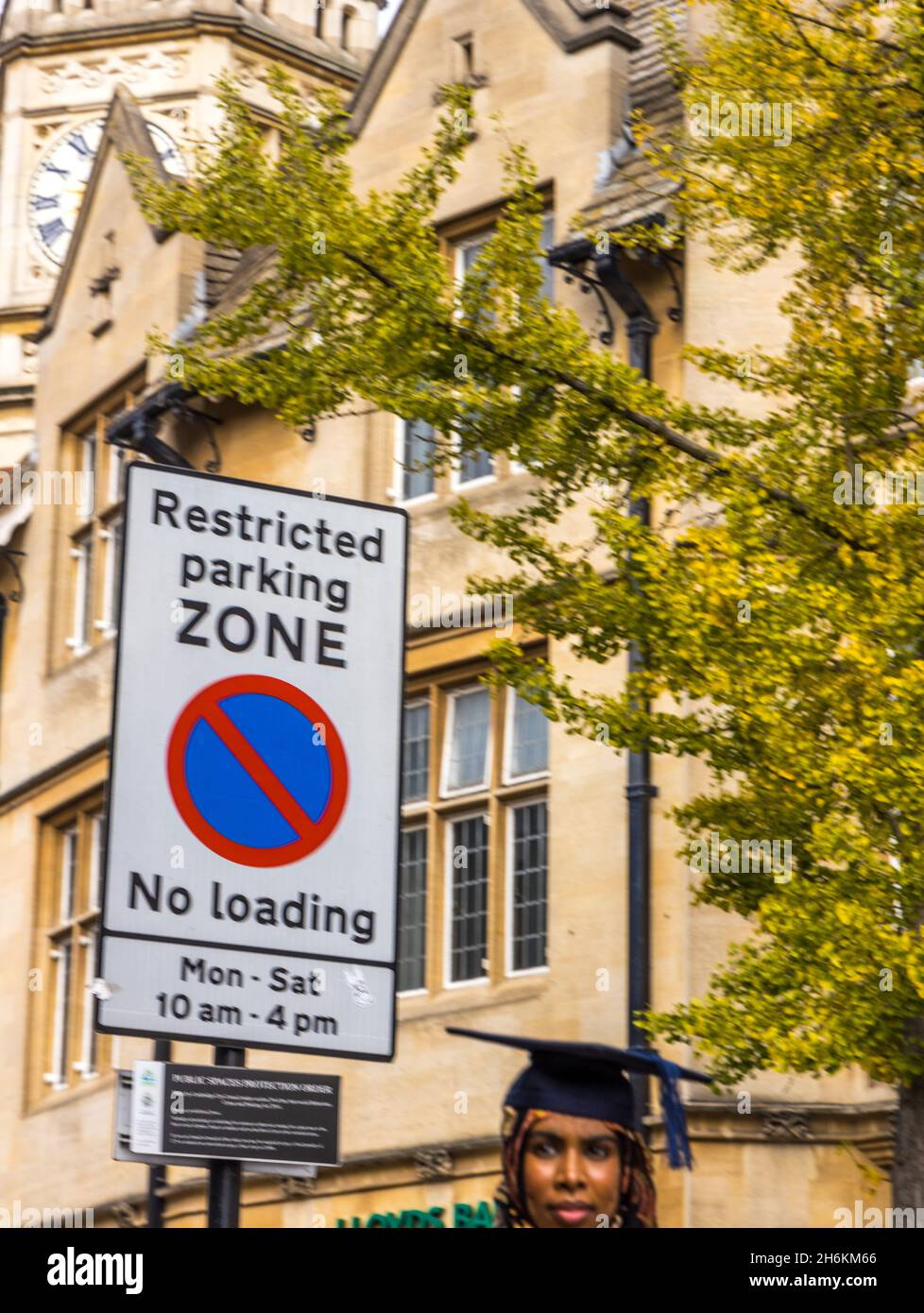 Restricted zone sign with female head in graduate mortarboard in foreground Stock Photo