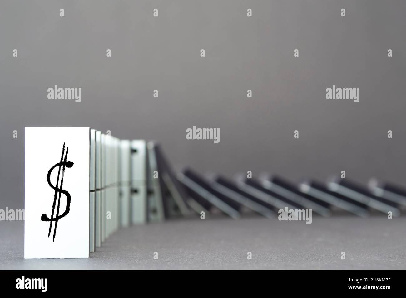 Dominoes falling in a row , gray background Stock Photo - Alamy