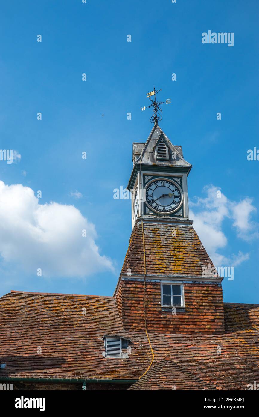 Clock tower with wind vane with west and east  letters and wind arrow indicating the points of the compass and the wind direction Stock Photo