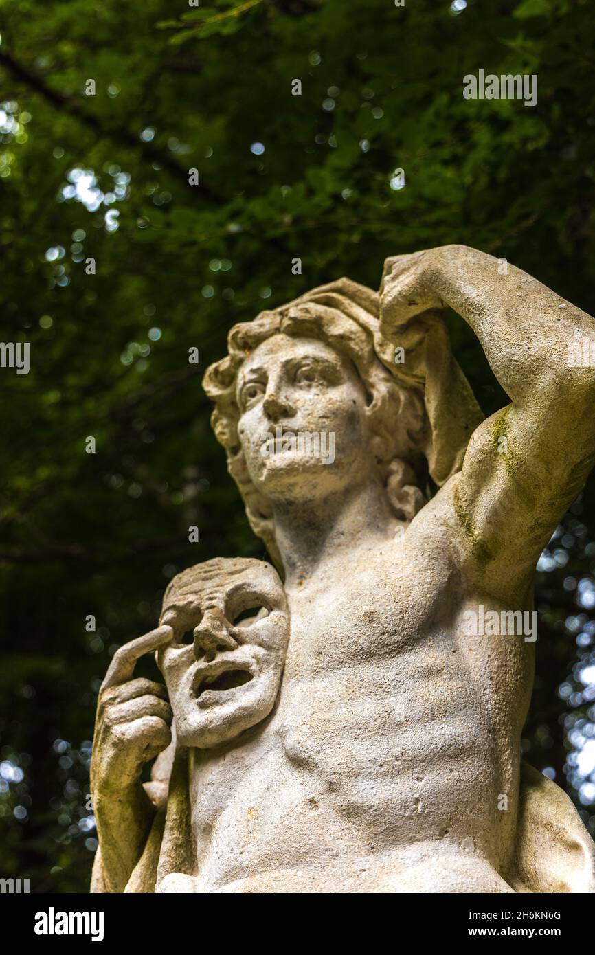 Strange statue holding a ghostly face mask at Anglesey Abbey Lode Cambridge England Stock Photo