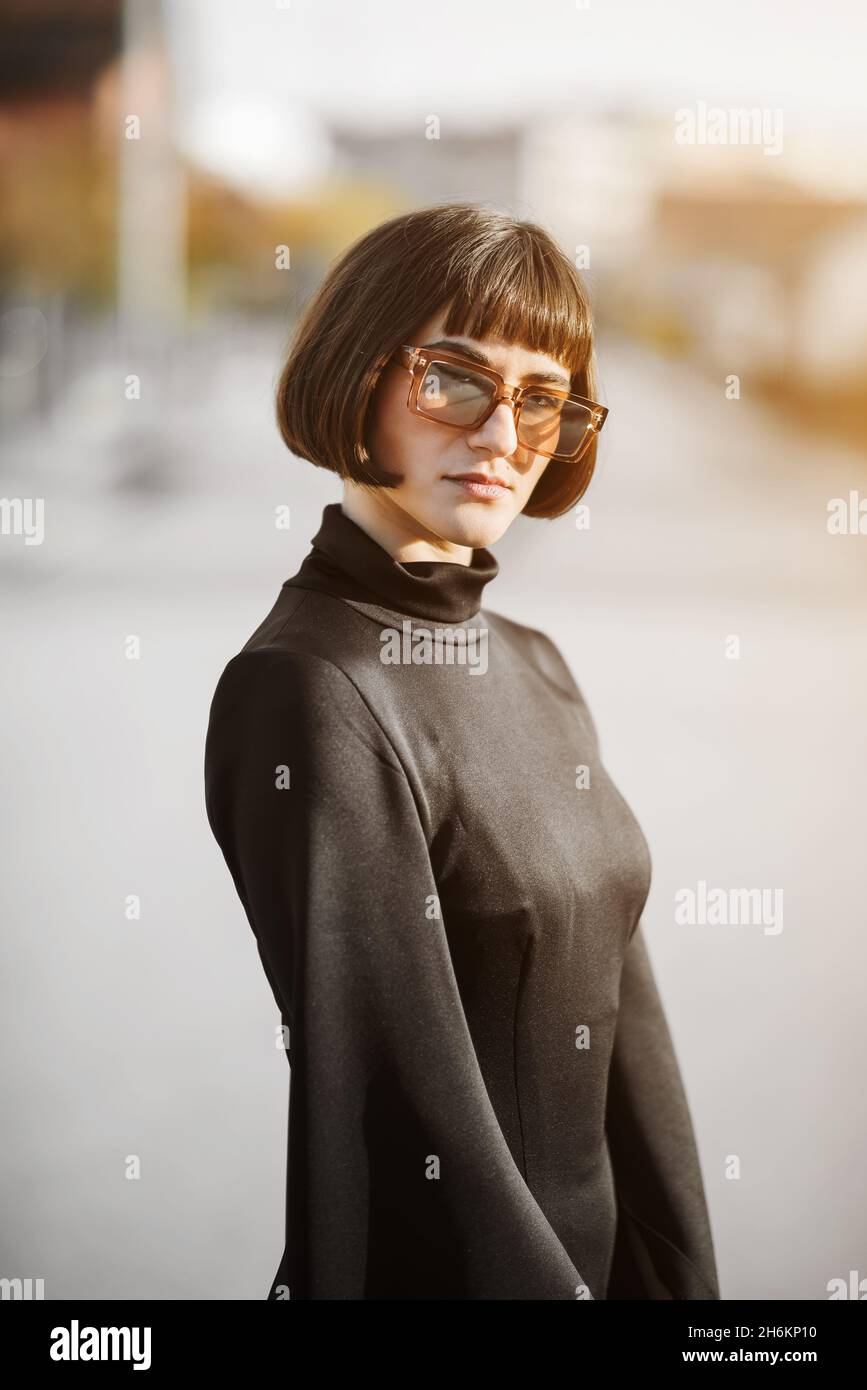 Fashionable young woman in black dress and sunglasses portrait, fashion and clothing concept Stock Photo