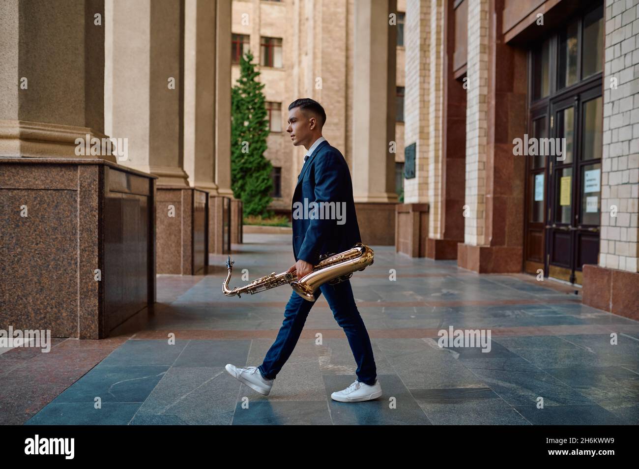 Male saxophonist holds instrument on the street Stock Photo Alamy