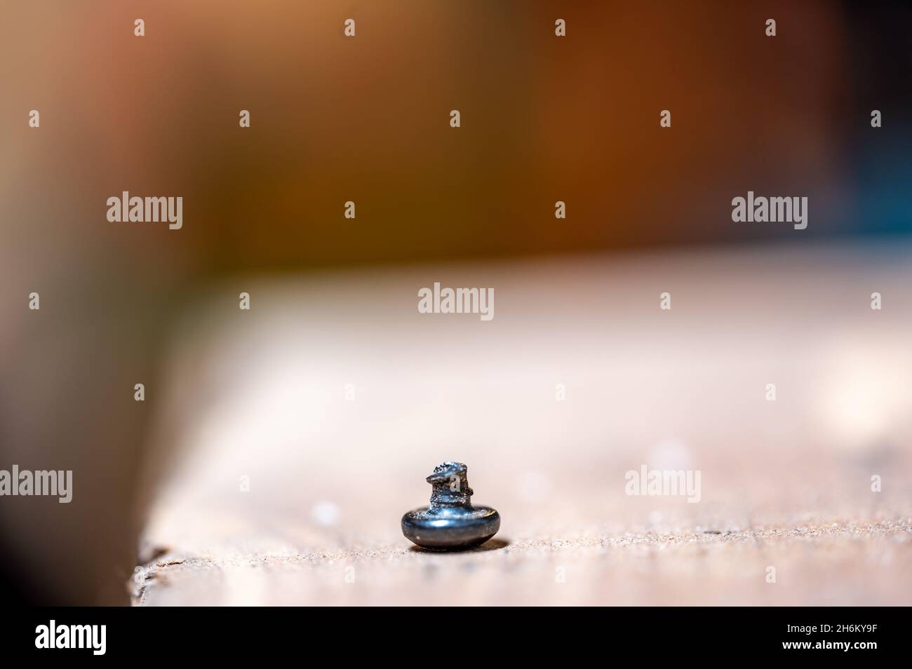 bolt head turned over to show sheared threading after stress failure