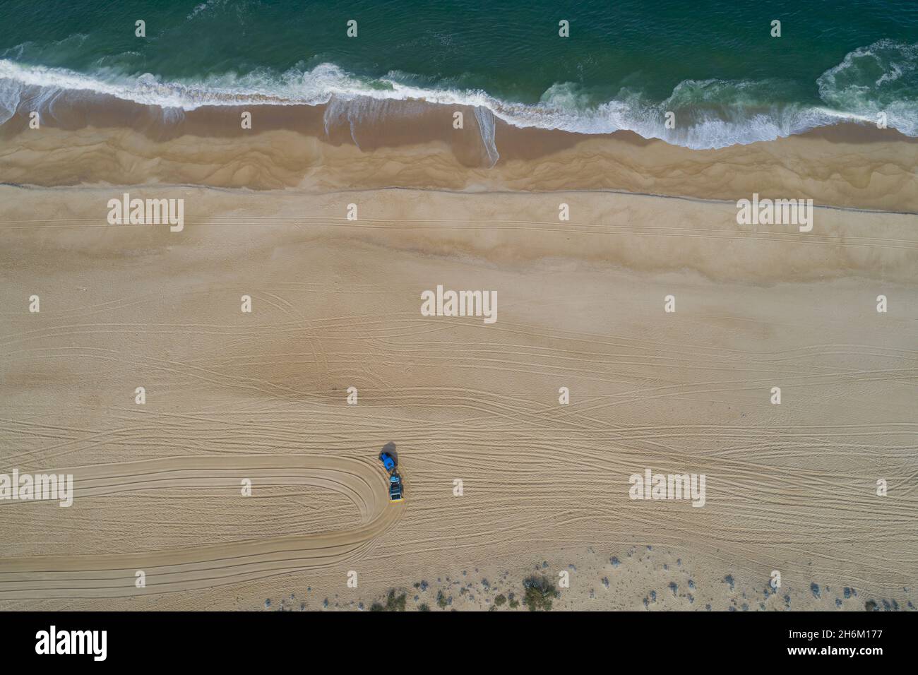 Aerial view of the wavy sea hitting the sandy beach on the coast Stock