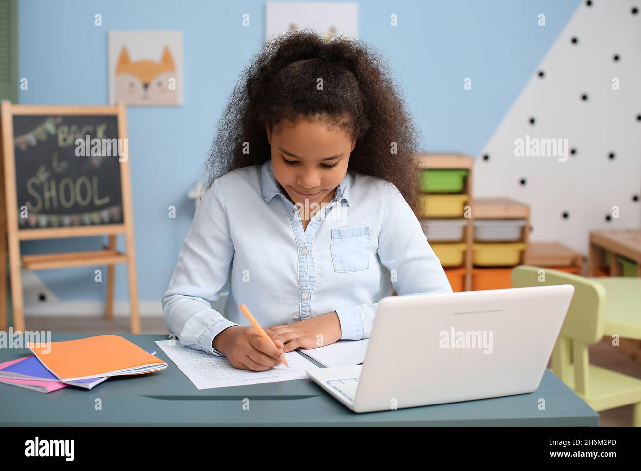 Little African-American girl studying online at home Stock Photo - Alamy