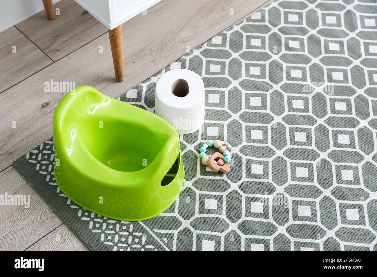 Green potty, rattle and toilet paper roll on floor Stock Photo - Alamy