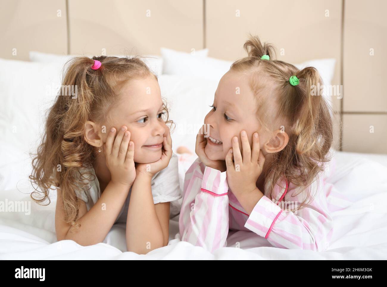 Adorable little girls lying on bed at home Stock Photo - Alamy