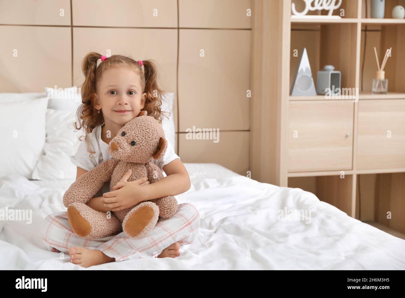 Adorable little girl with teddy bear in bedroom Stock Photo - Alamy