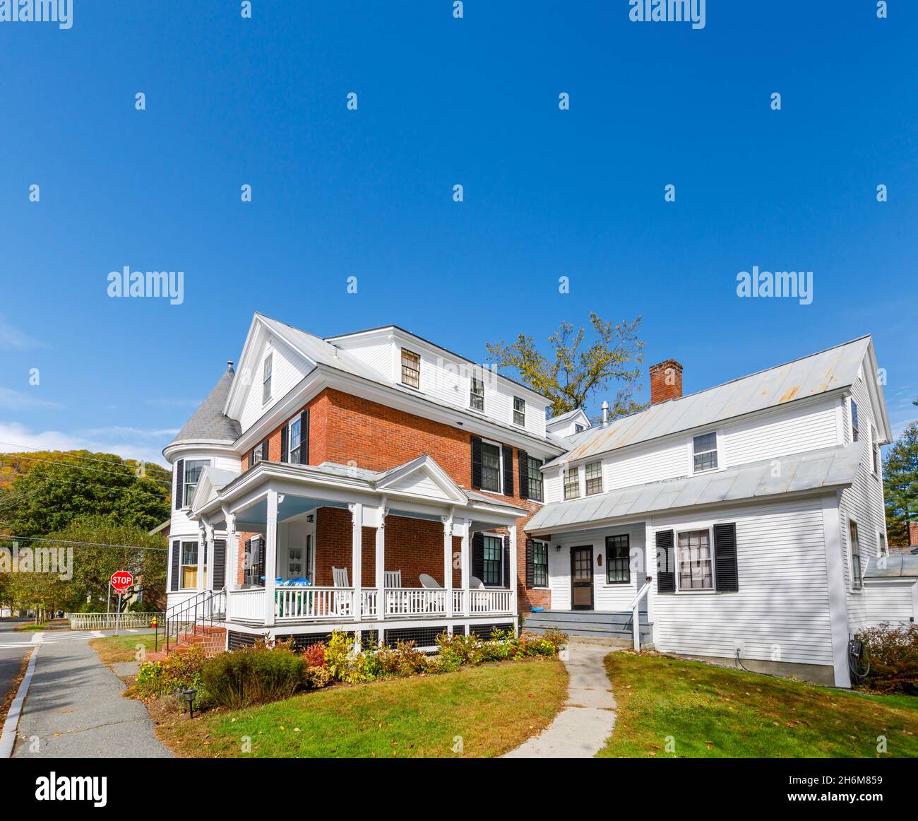 Typical local style large white clapboard faced house with a verandah in Woodstock, Vermont, New