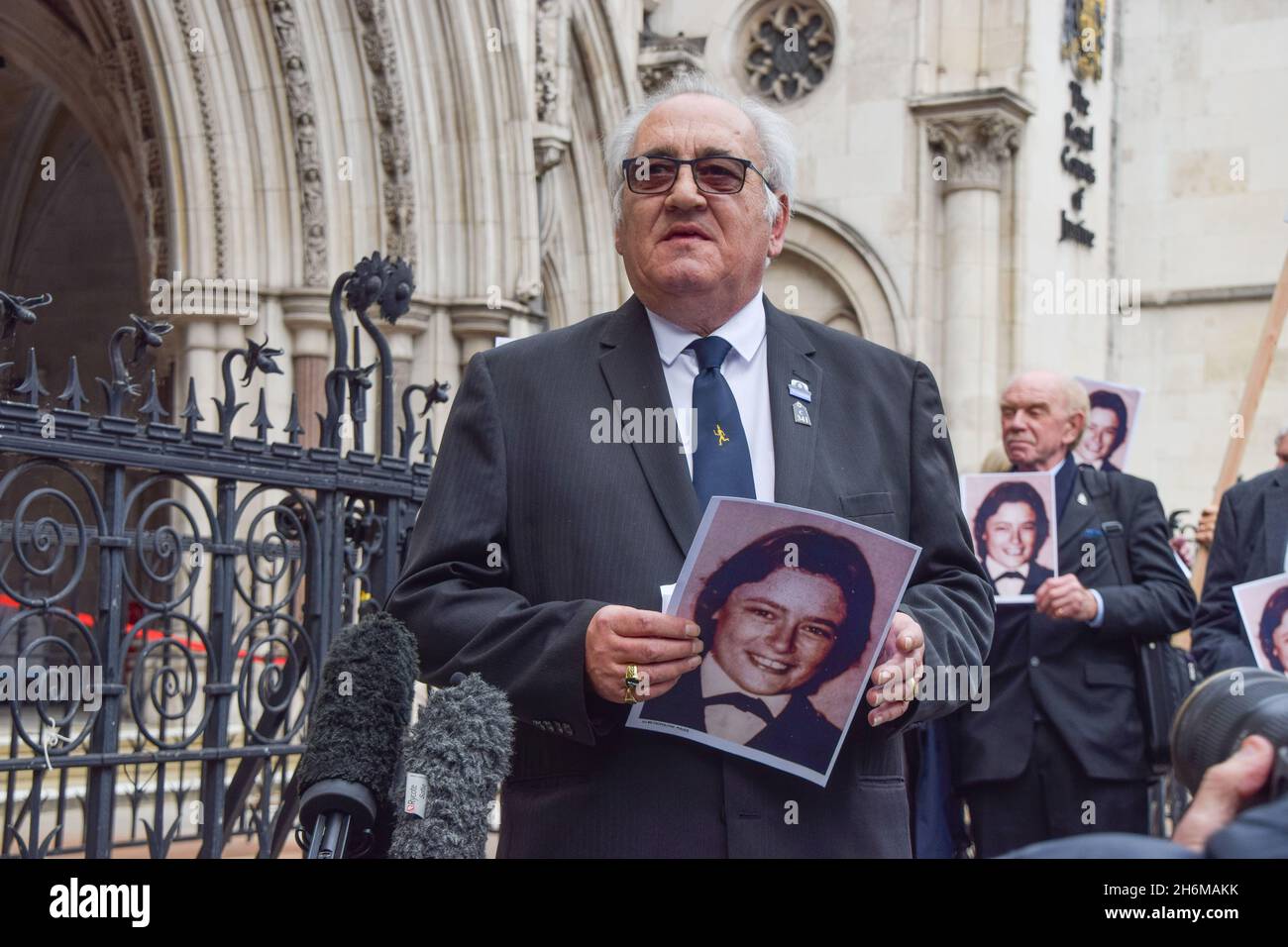London, UK. 16th Nov, 2021. Retired police officer, John Murray holds a portrait of Yvonne Fletcher outside the Royal Courts of Justice. Saleh Ibrahim Mabrouk, a Libyan man close to Gaddafi, has been found jointly responsible for the fatal shooting of police officer Yvonne Fletcher outside the Libyan Embassy in 1984, in a civil case brought by her former colleague and friend, John Murray. Credit: SOPA Images Limited/Alamy Live News Stock Photo