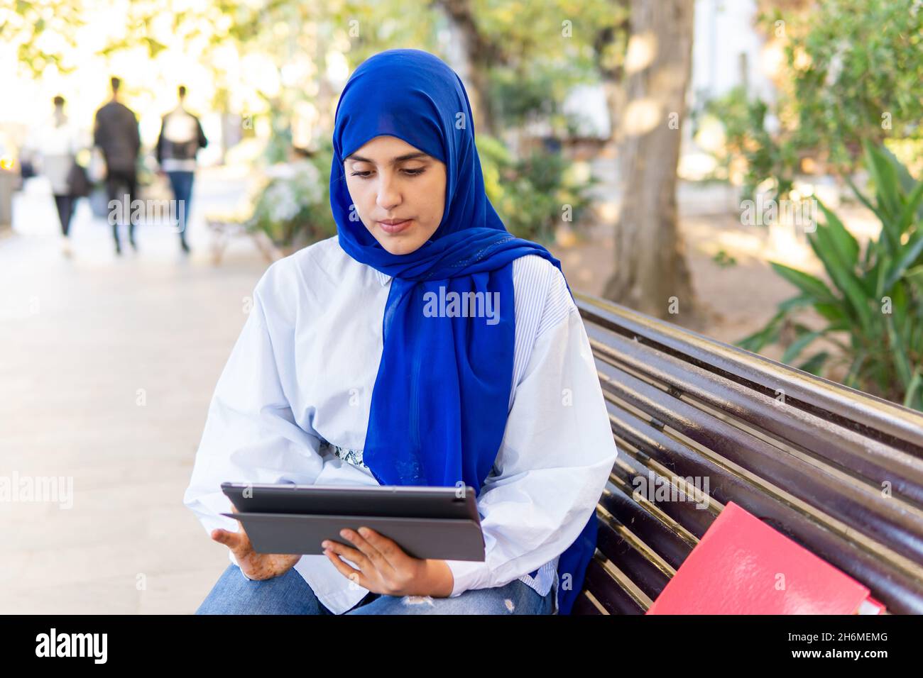 Young muslim woman wearing hijab using a tablet sitting in the u Stock ...