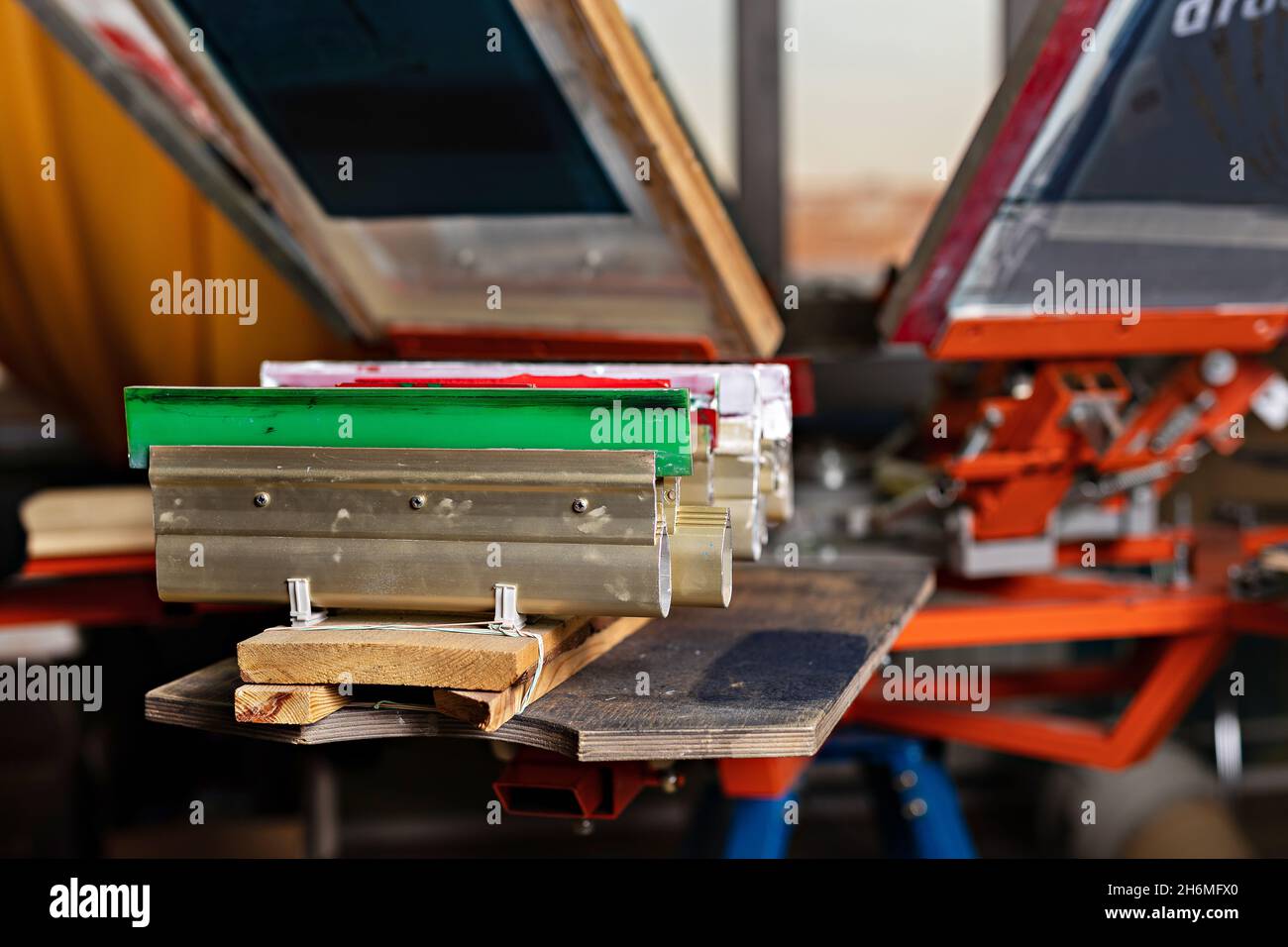 squeegees on wooden shelve of the print screening apparatus. serigraphy