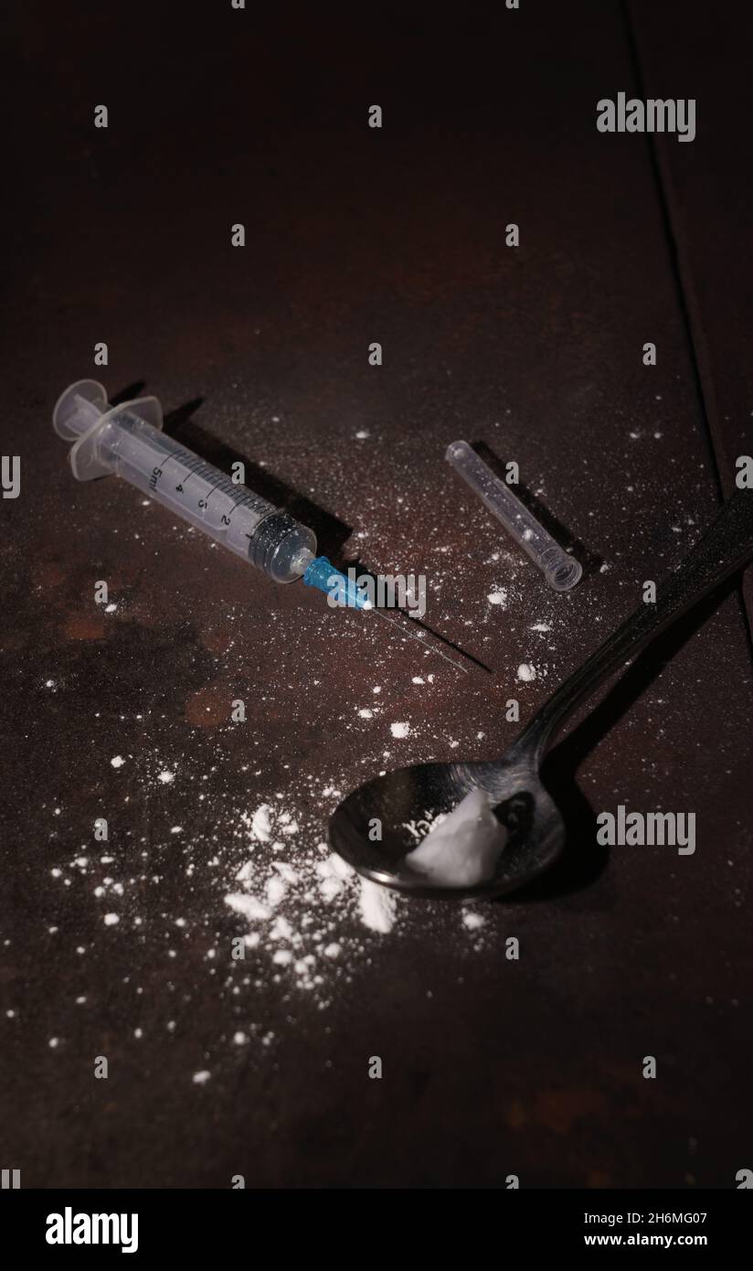 Dirty Syringe and spoon on the floor used to inject drugs with copy space Stock Photo