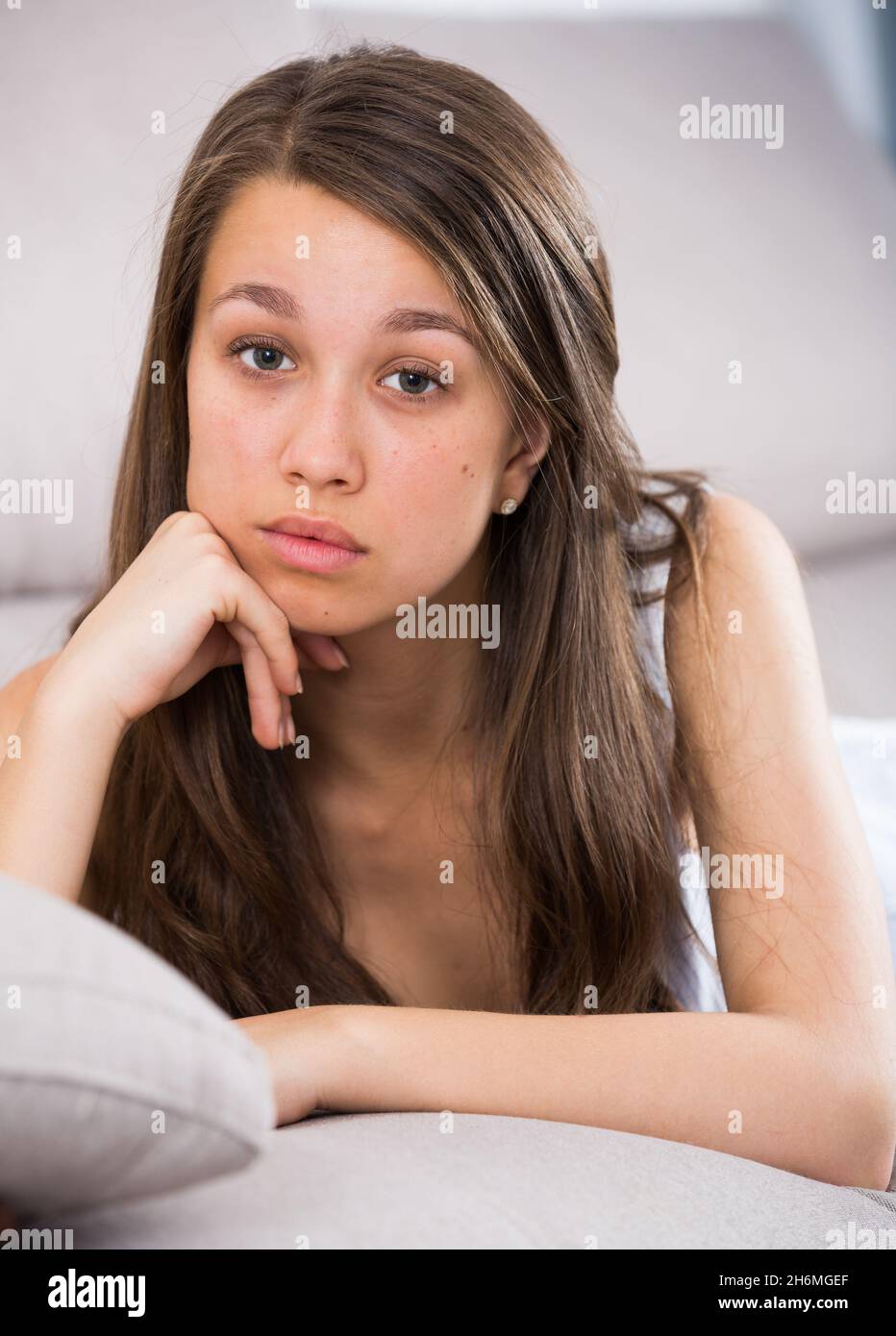 Woman is lying stressed and lonely on sofa Stock Photo