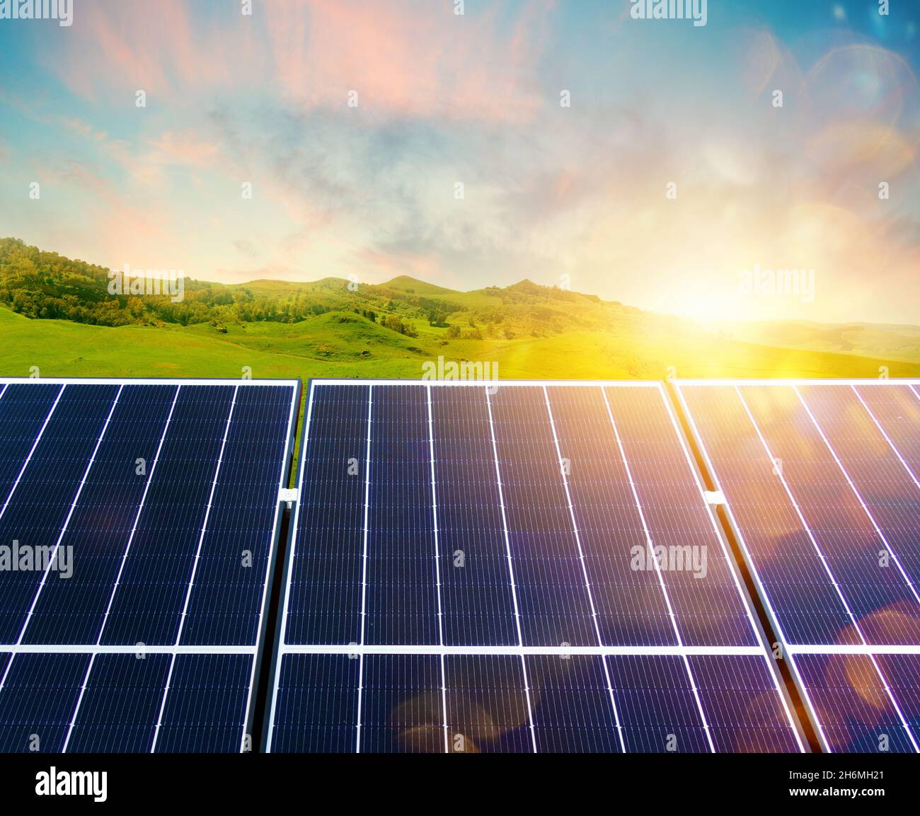 Renewable energy system with solar panel and green mountain Stock Photo