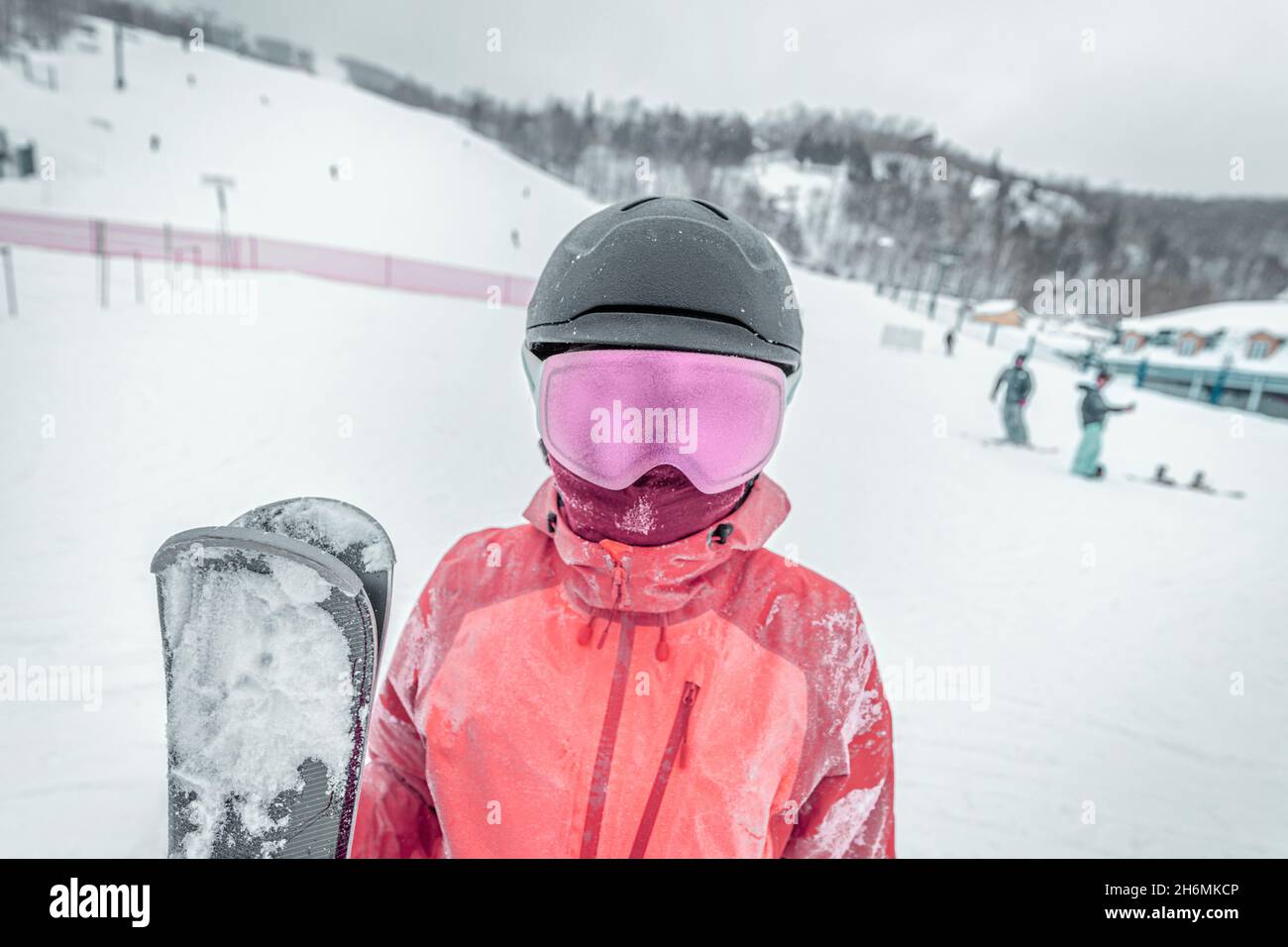 Iced up frozen ski goggles and ski helmet on woman looking at camera with ski goggles icing up in freeze. Concept of Glaze ice, also called glazed Stock Photo