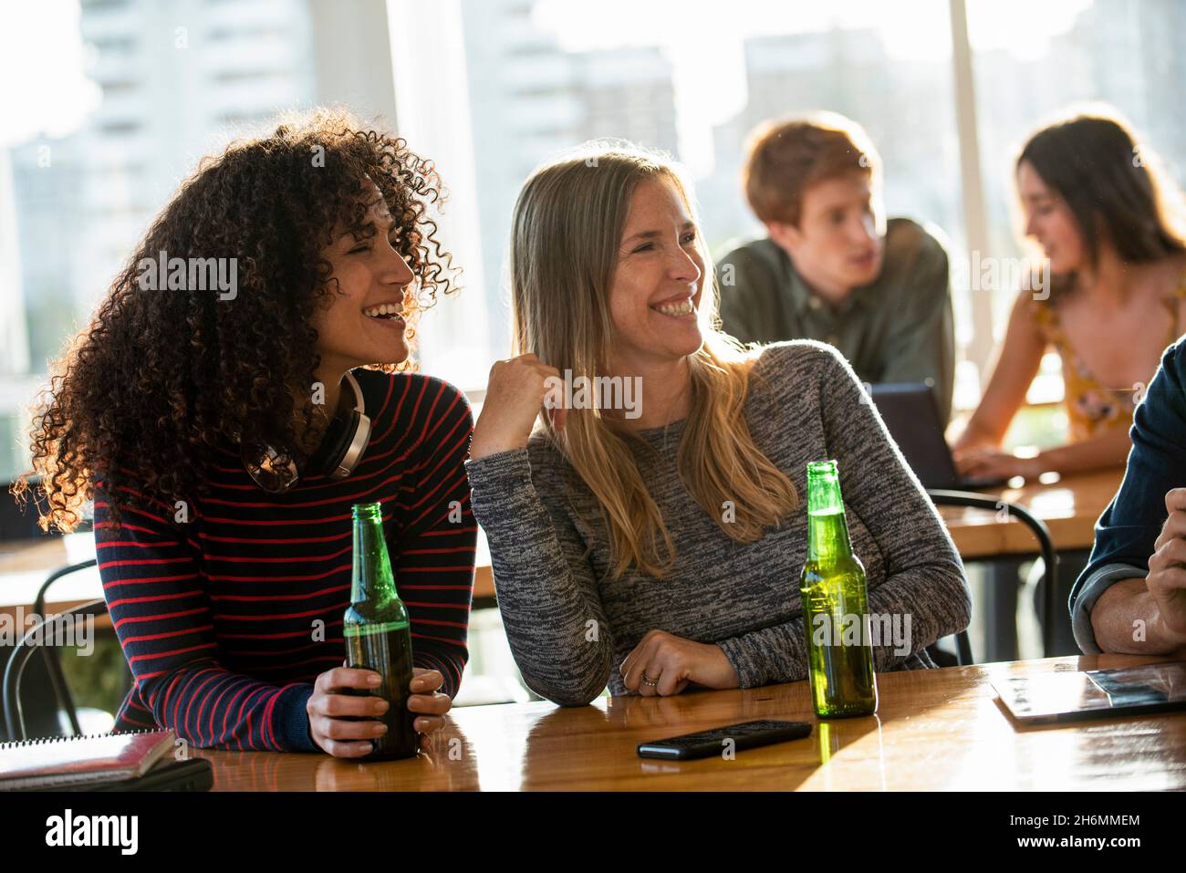 Smiling women looking away while sitting in office Stock Photo