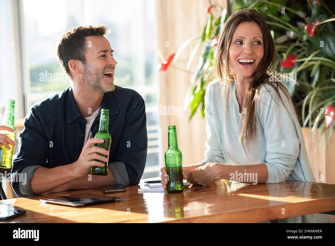 Couple having a beer in office Stock Photo