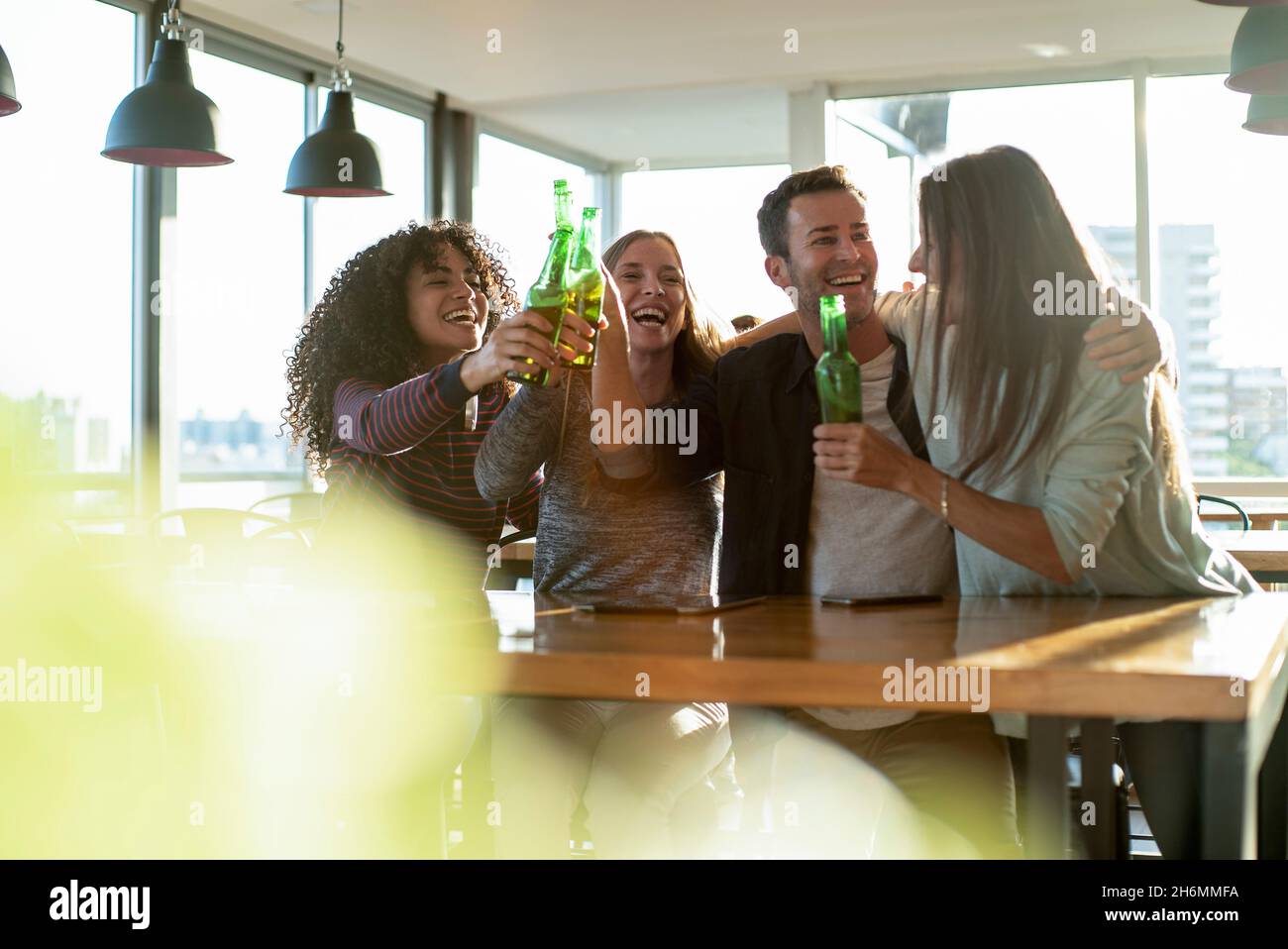 Smiling colleagues toasting drink bottles in office Stock Photo