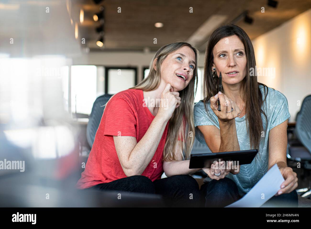 Thoughtful businesswomen working in office Stock Photo