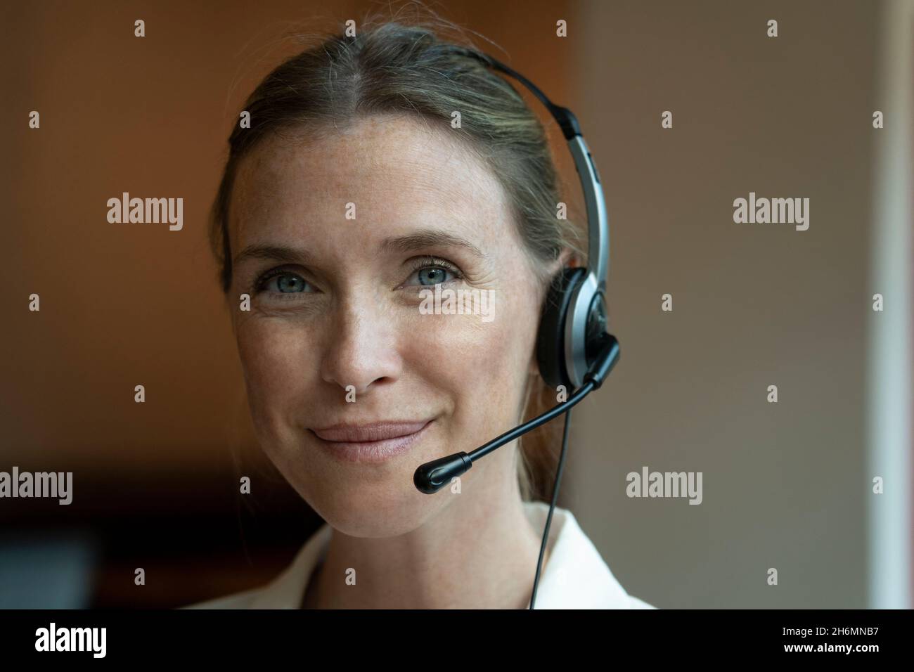 Portrait of mature woman wearing headset in office Stock Photo