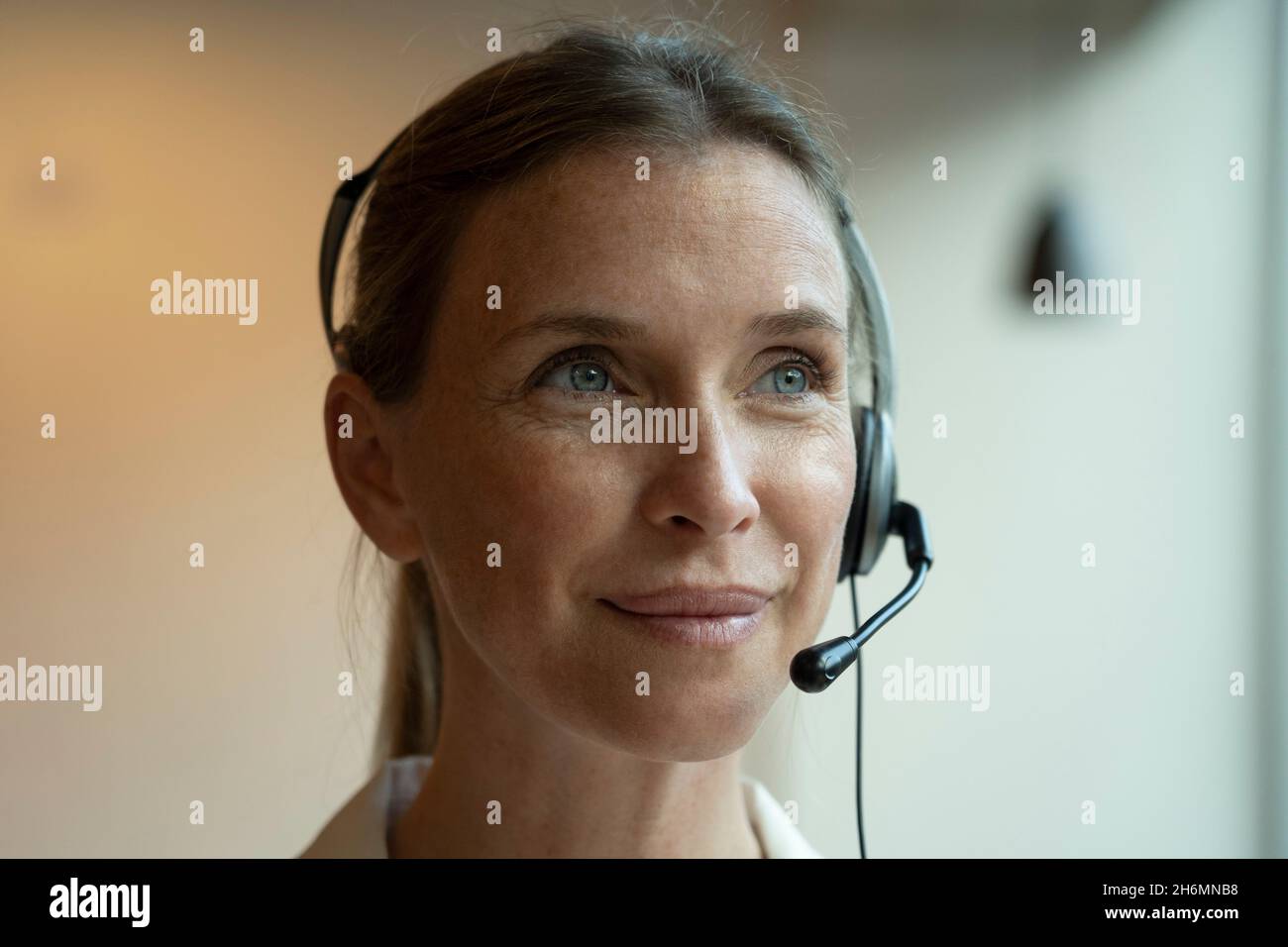 Close-up of mature woman wearing headset Stock Photo