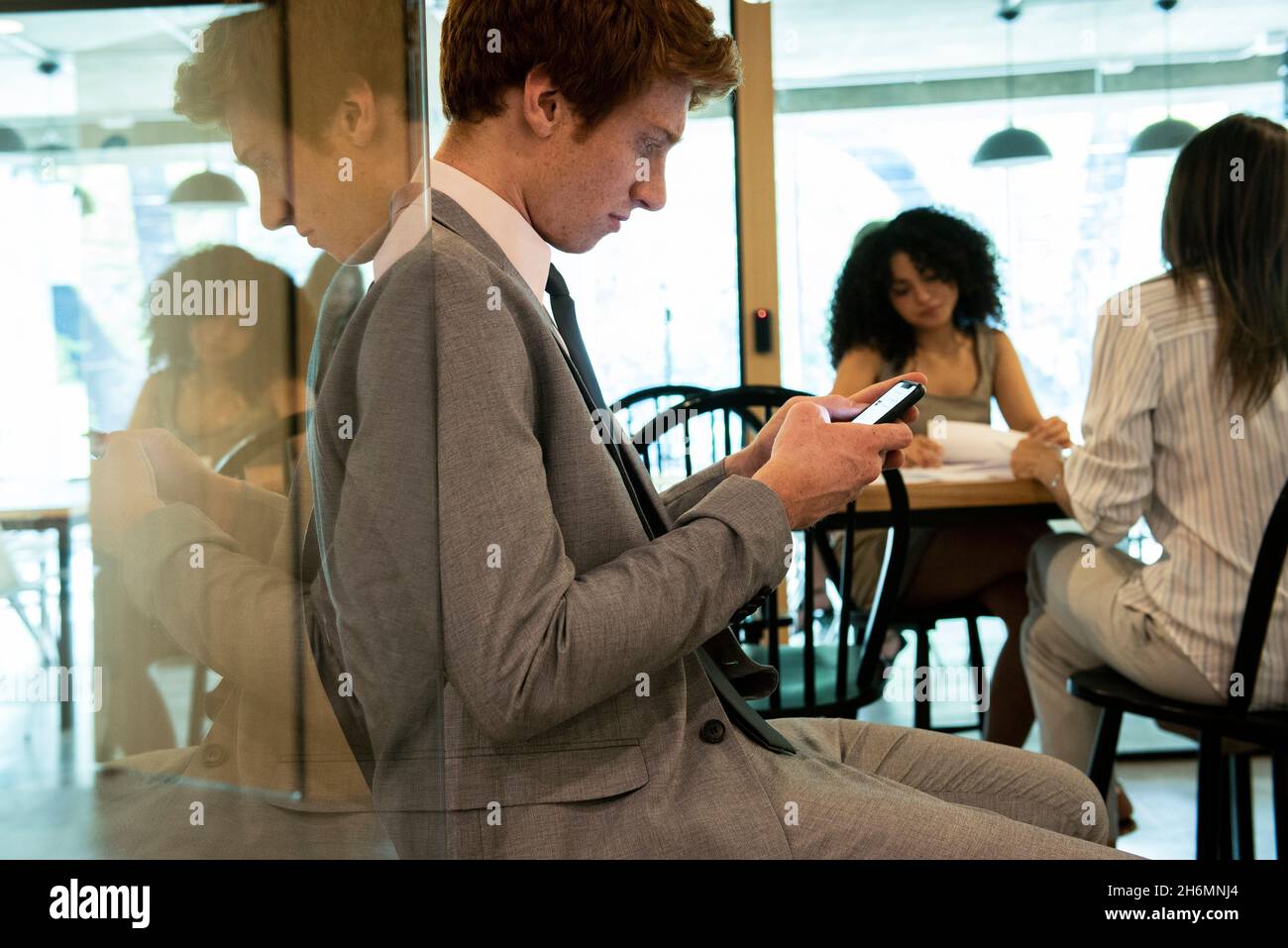 Young businessman using smart phone in office Stock Photo