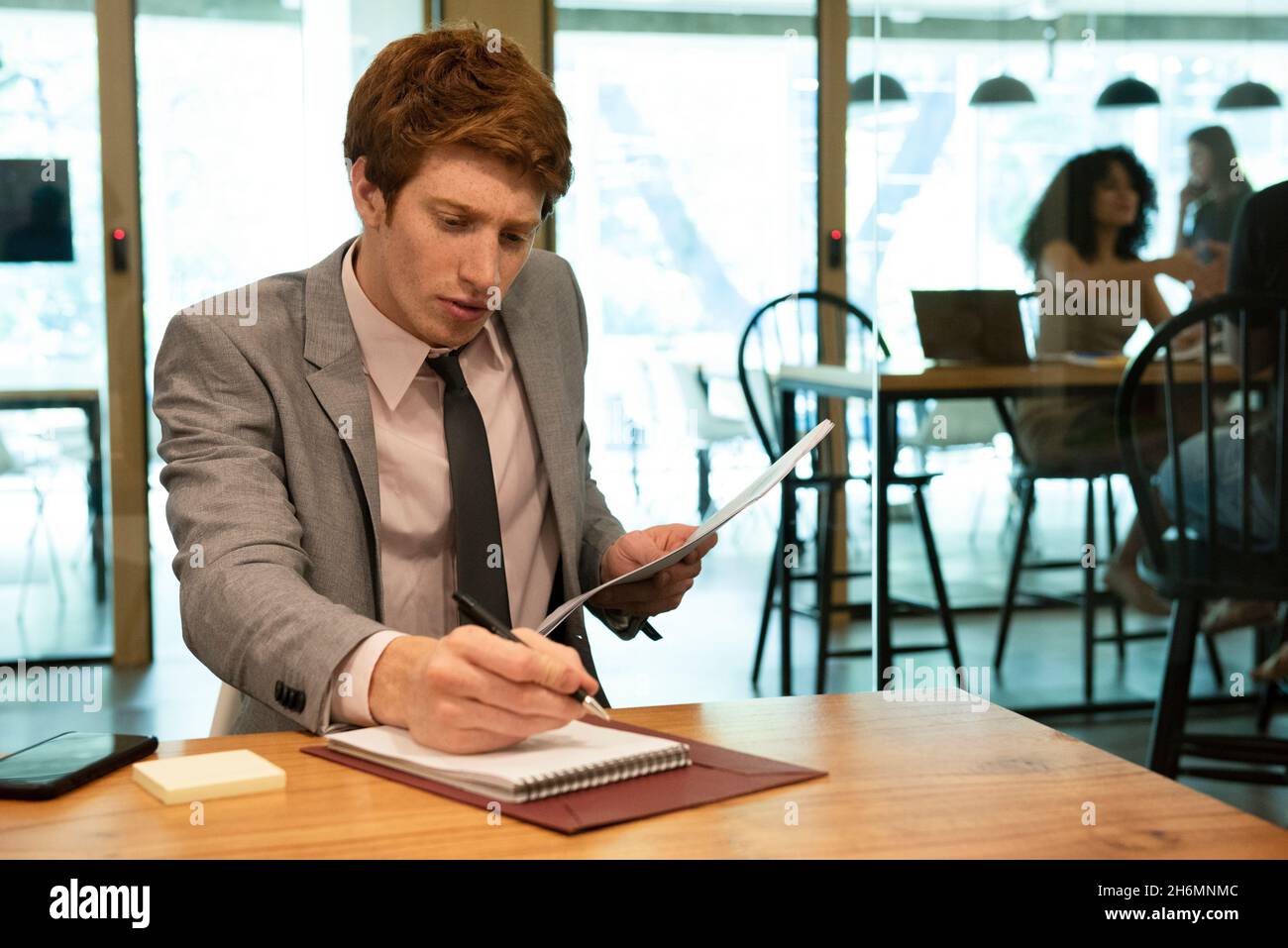 Young businessman writing on notebook in office Stock Photo