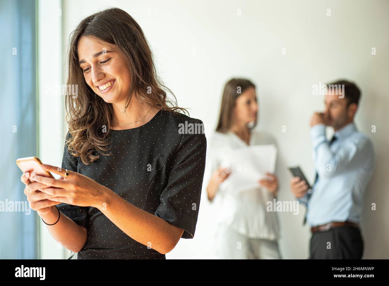 Smiling businesswoman using smart phone Stock Photo