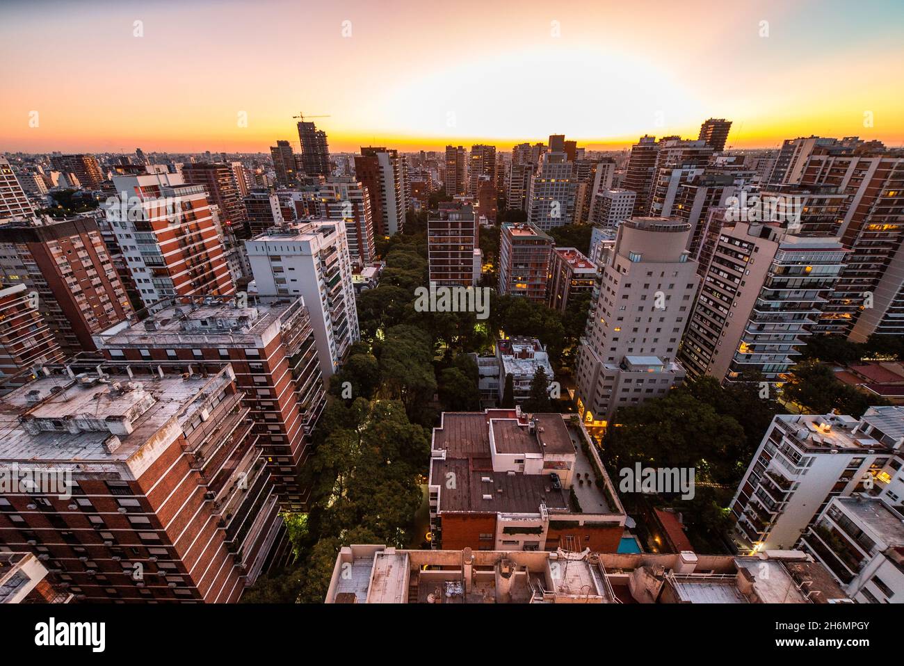 Aerial view of crowded cityscape with high rise buildings at sunset ...