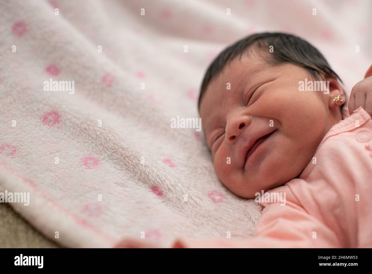 Cute Hispanic baby girl sleeping on a white and pink blanket Stock Photo Alamy