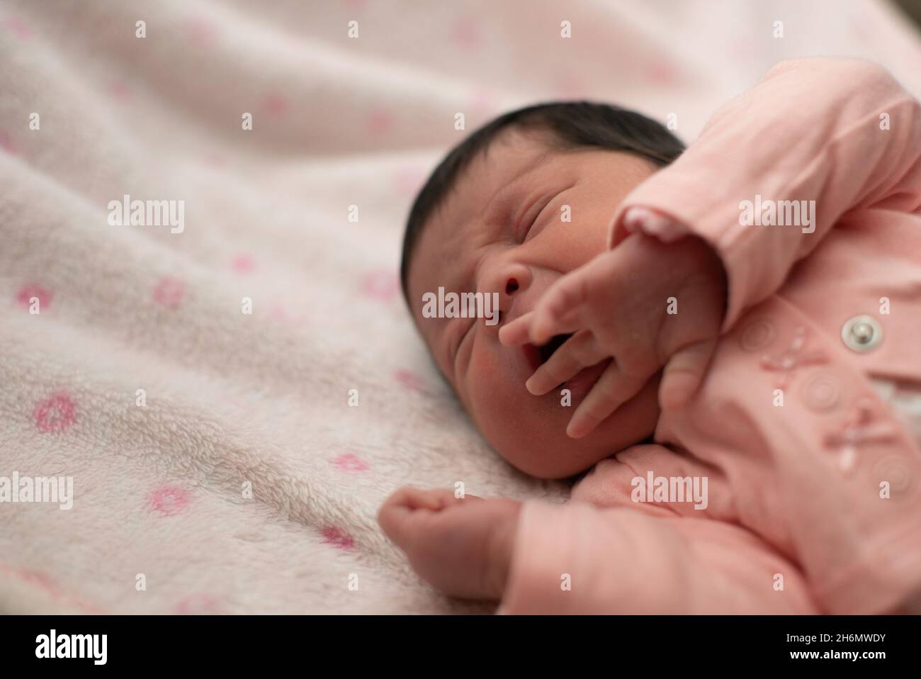 Cute Hispanic baby girl sleeping on a white and pink blanket Stock Photo Alamy