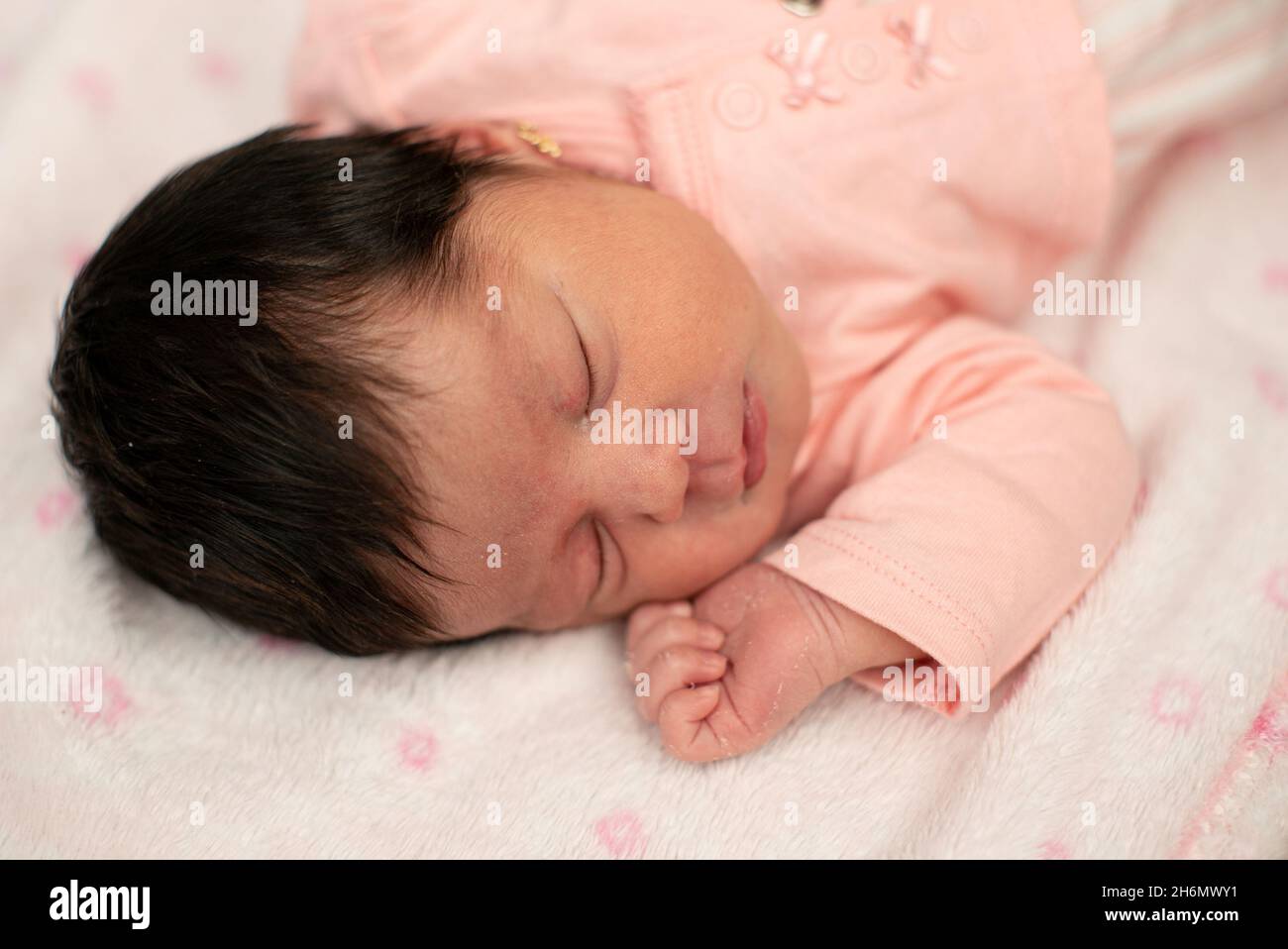 Cute Hispanic baby girl sleeping on a white and pink blanket Stock Photo Alamy