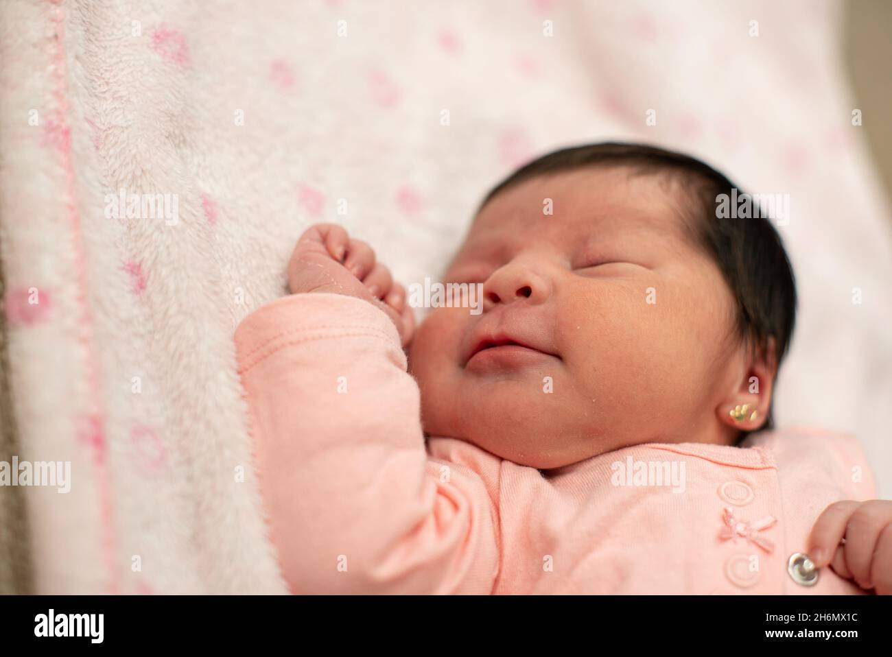 Cute Hispanic baby girl sleeping on a white and pink blanket Stock Photo Alamy