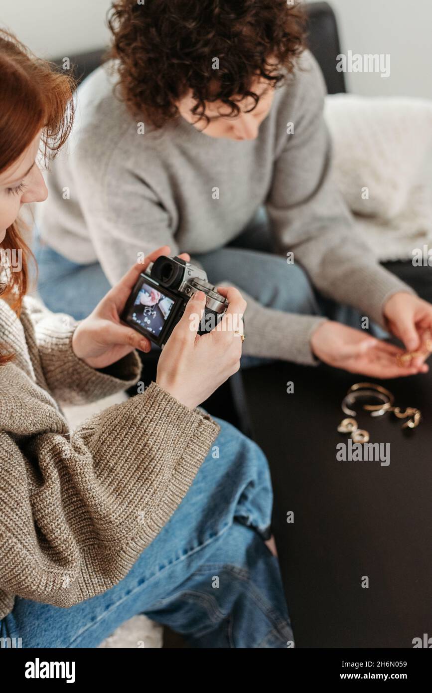 Vertical shot of two female friends taking photos of jewelry Stock Photo