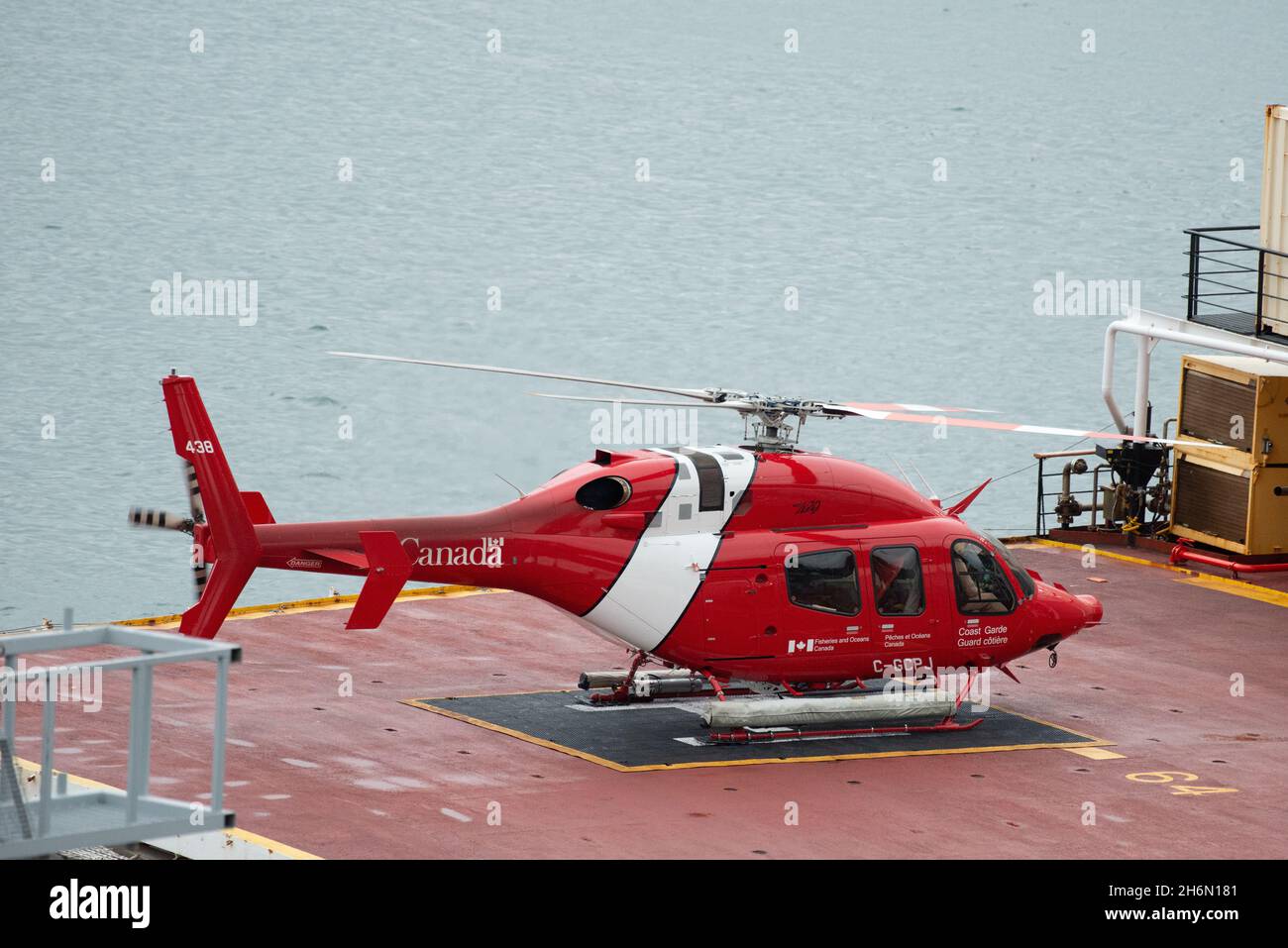A Canadian Coast Guard cormorant helicopter or chopper on the helipad of a large Coast Guard ship. The emergency response air transport has it gear do Stock Photo