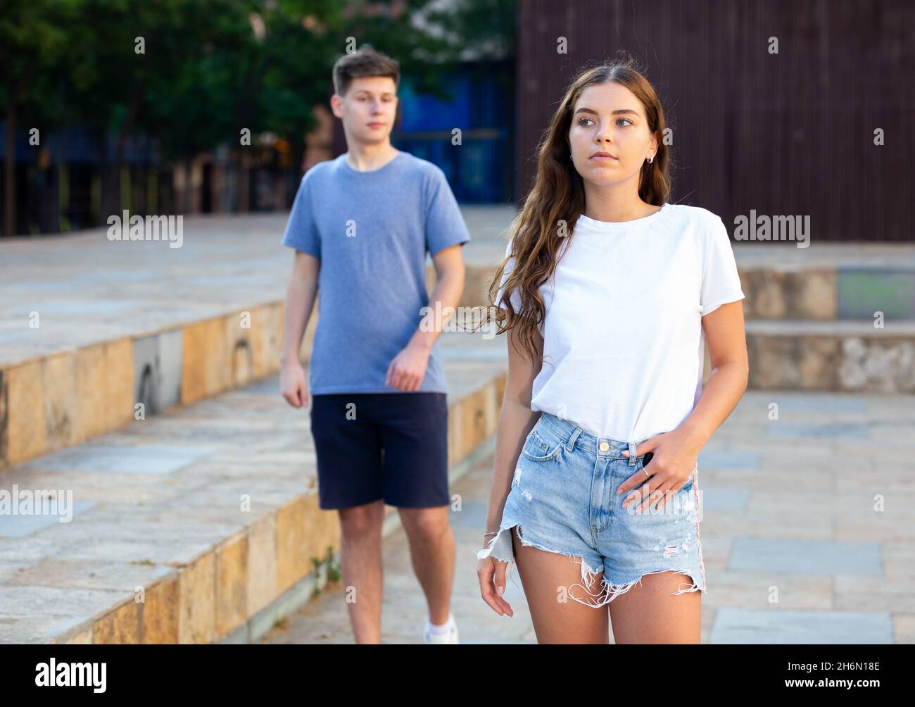Cute teen girl in denim shorts walking down street Stock Photo Alamy