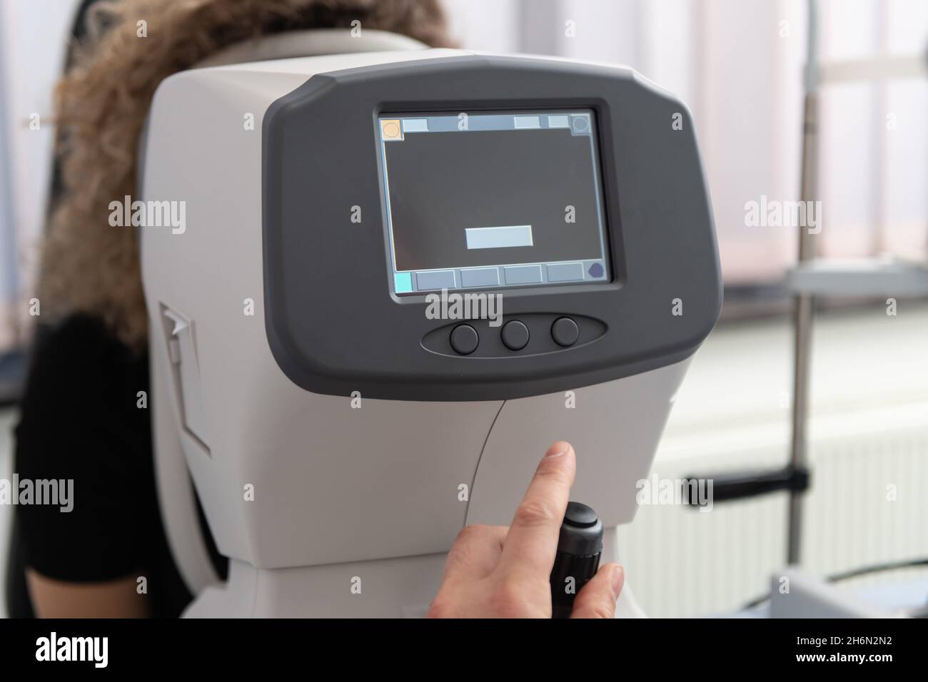 Woman Looking at Refractometer Eye Test Machine in Ophthalmology Stock
