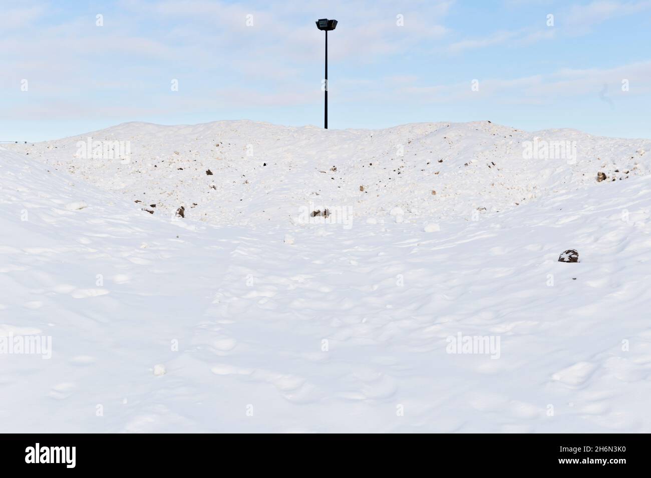 A streetlight peeks over a mound of cleared snow by the Colisee Jean
