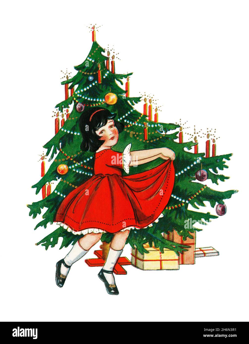 Young girl dancing in front of Christmas tree Stock Photo