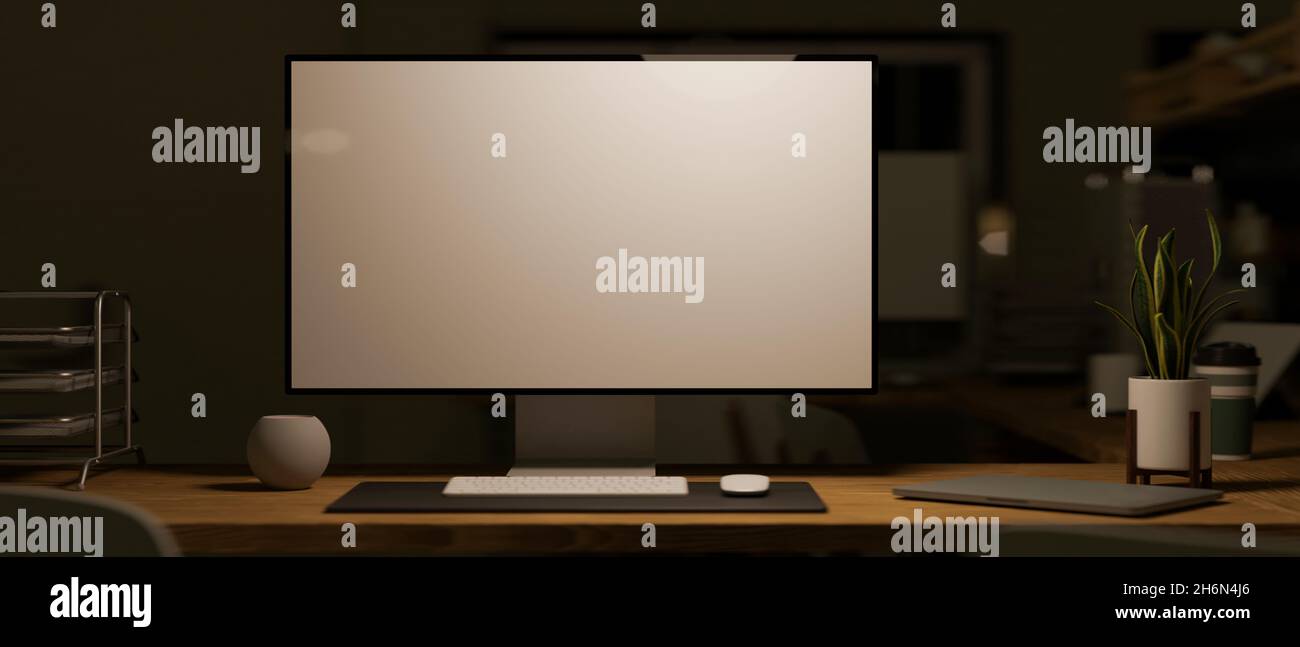 Modern pc computer white screen mockup on working desk in dark office