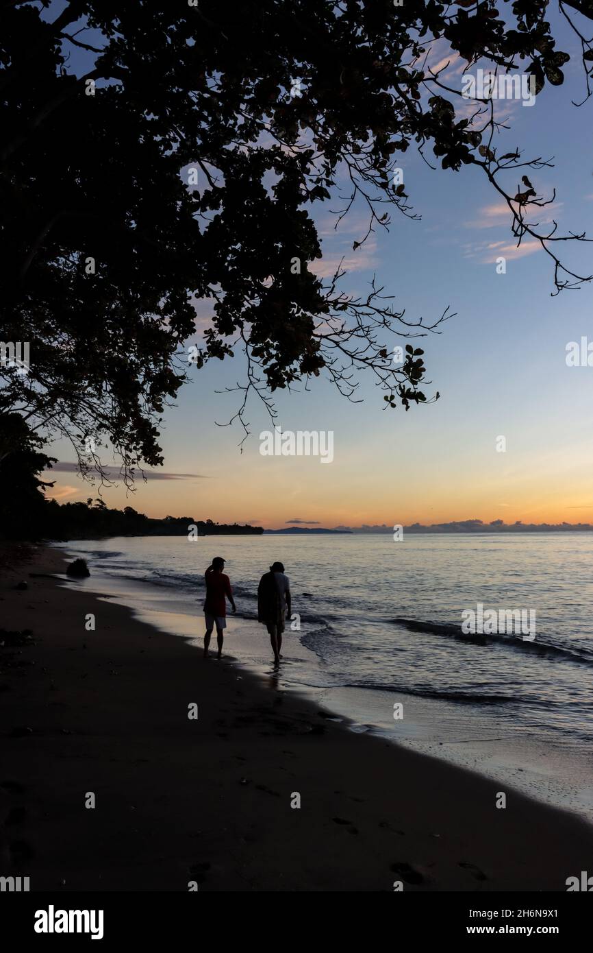 silhouette photo of two people walking on the beach in the morning ...