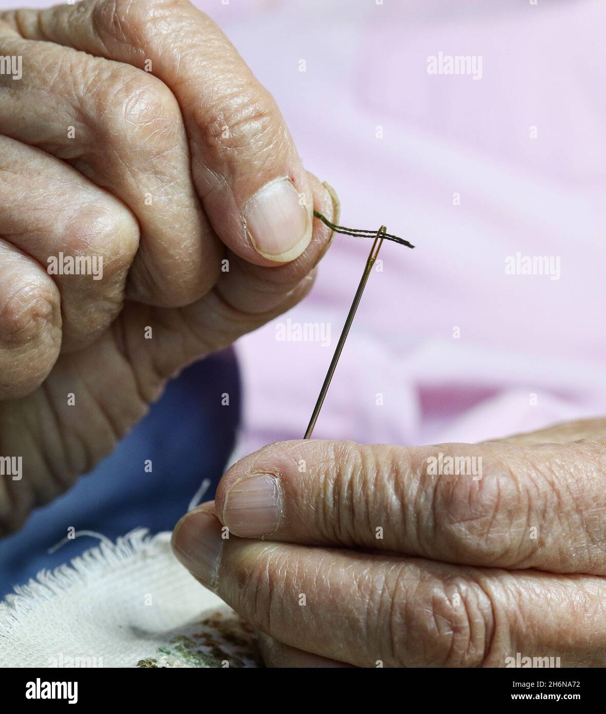 Generic image of  female elderly hands using a needle to sew. Stock Photo